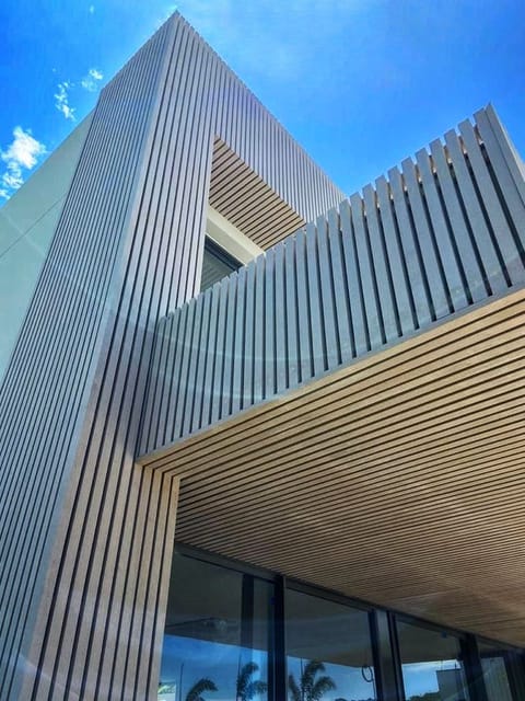 Brises de madeira ecológica compondo volume de fachada contemporânea
