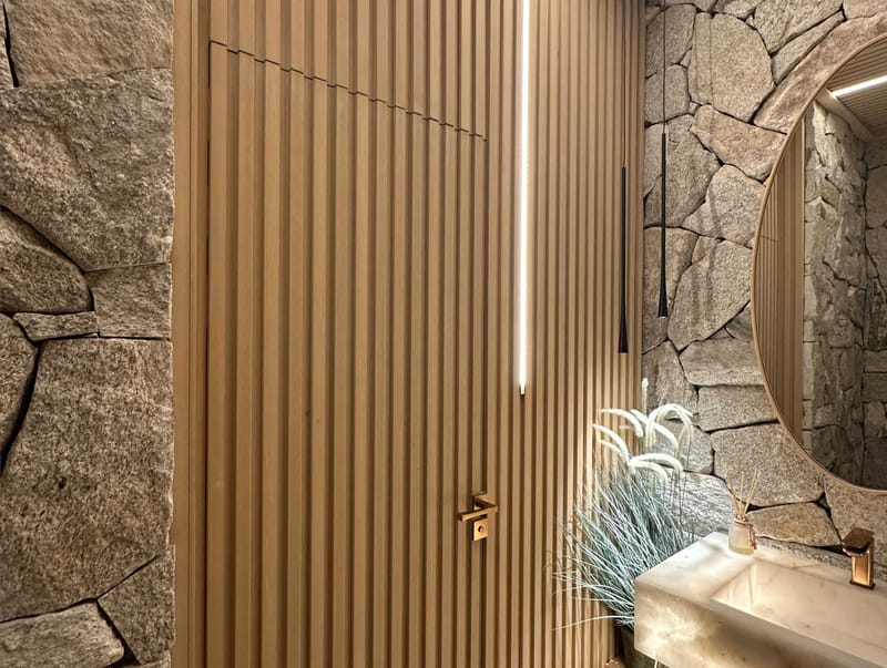 Lavabo com ripado de madeira ecológica EcoÚtil combinado com pedra natural e espelho oval