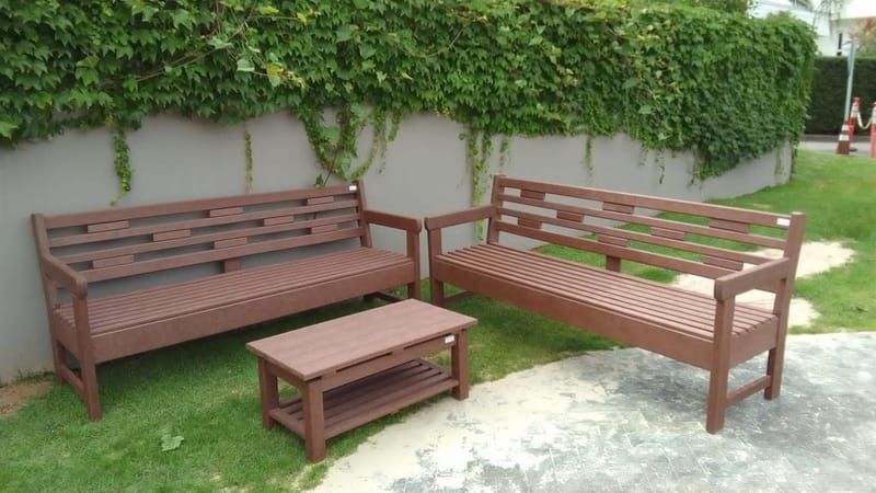 Conjunto de bancos e mesa de centro em madeira ecológica em jardim com muro verde