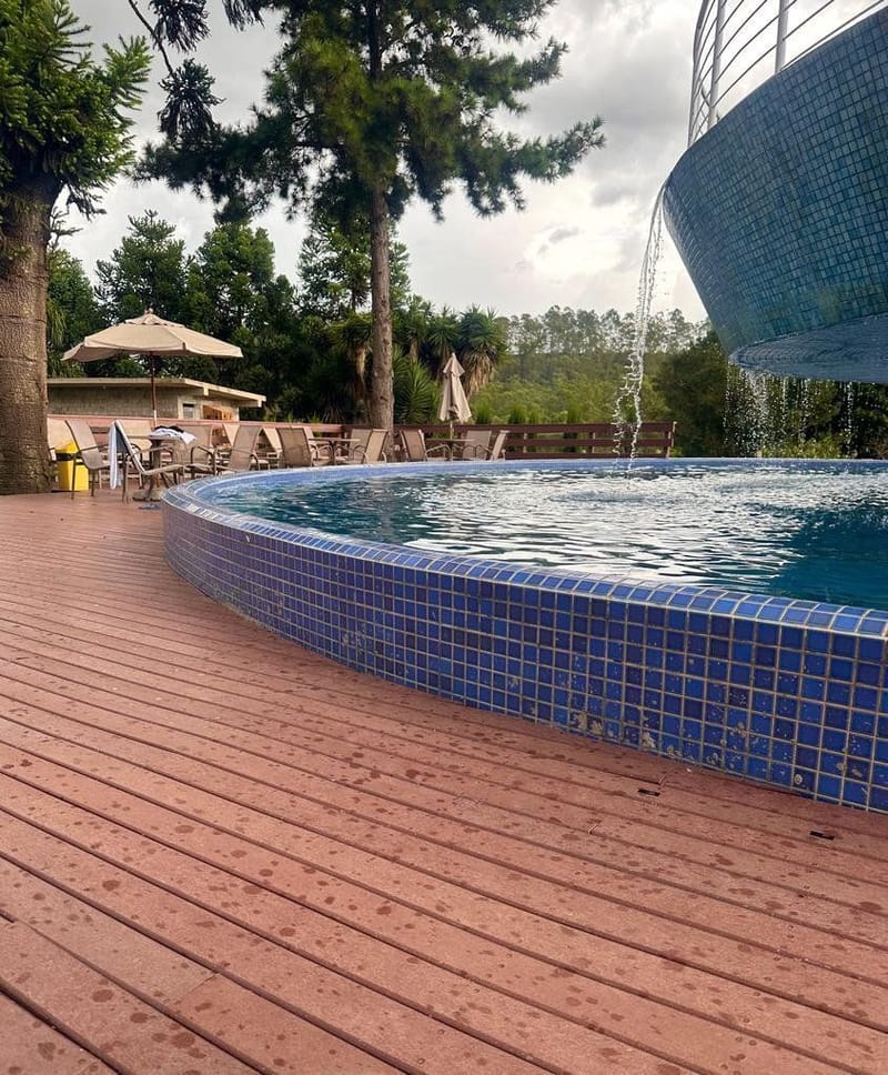 Deck curvo de madeira ecológica na borda de piscina de condomínio