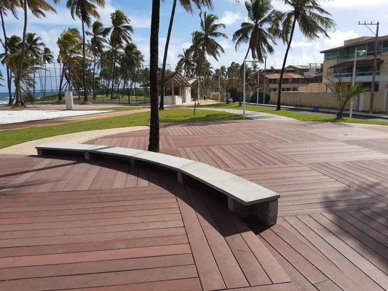 Praça pública revitalizada com deck e banco em madeira ecológica EcoÚtil ao redor de palmeiras