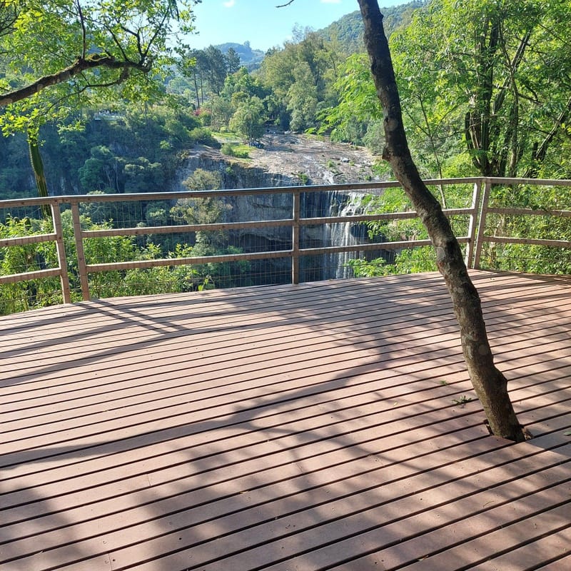 Deck mirante em madeira plástica maciça com árvore preservada e vista para a serra