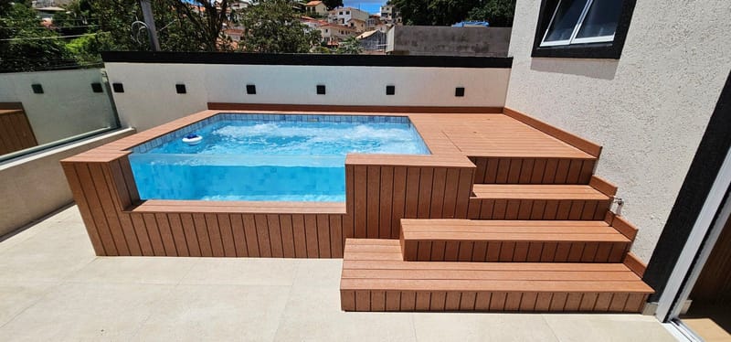 Piscina elevada em cobertura revestida em madeira plástica maciça com escada