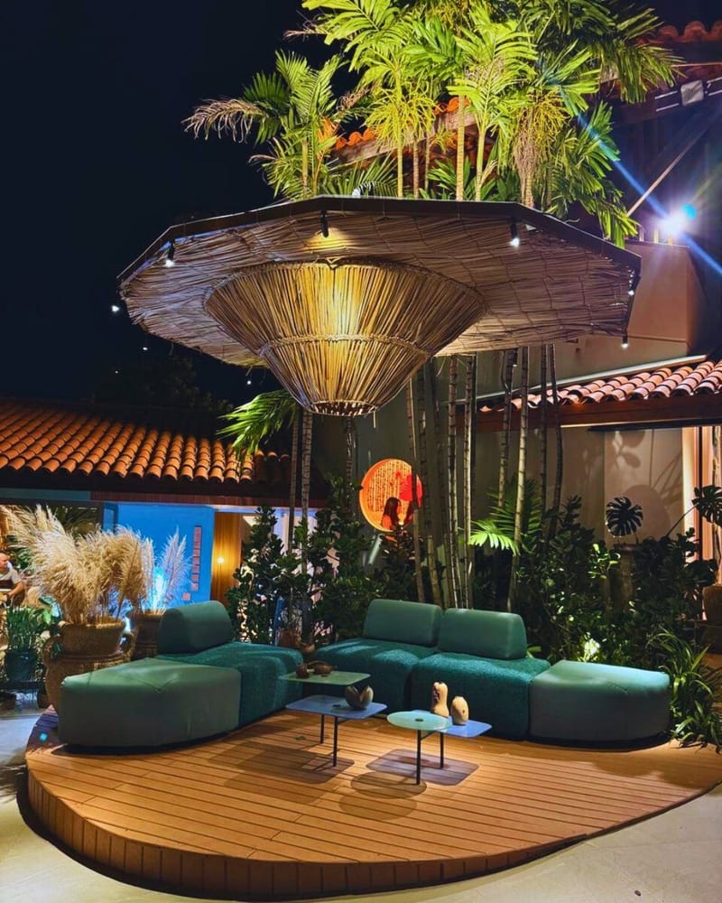 Deck curvo de madeira plástica maciça em lounge noturno com paisagismo