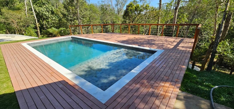 Piscina com deck EcoDeck Supremo de madeira plástica maciça em meio à mata no Rio de Janeiro