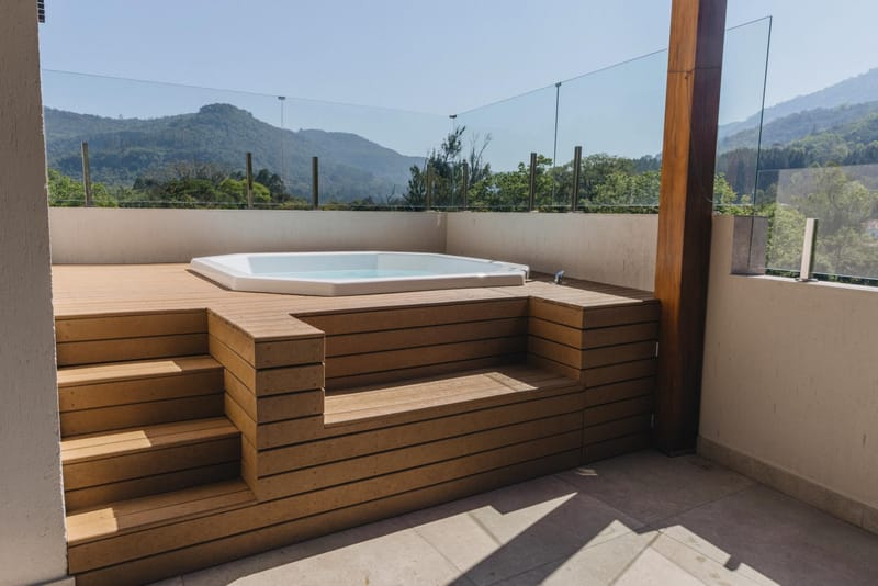 Spa de hidromassagem embutido em deck de madeira ecológica EcoÚtil com degraus e vista para a serra, Rio de Janeiro