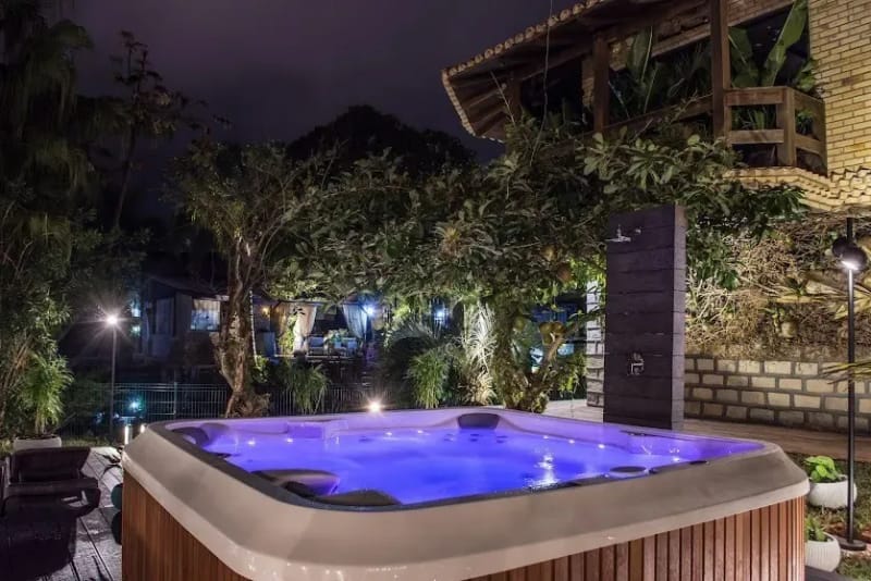 Spa iluminado à noite no deck de madeira