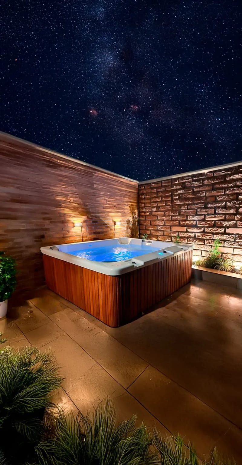 Spa iluminado à noite em deck de madeira ecológica, sob céu estrelado