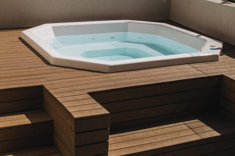 Spa octogonal emoldurado por deck e degrau de madeira ecológica EcoÚtil cor cumaru