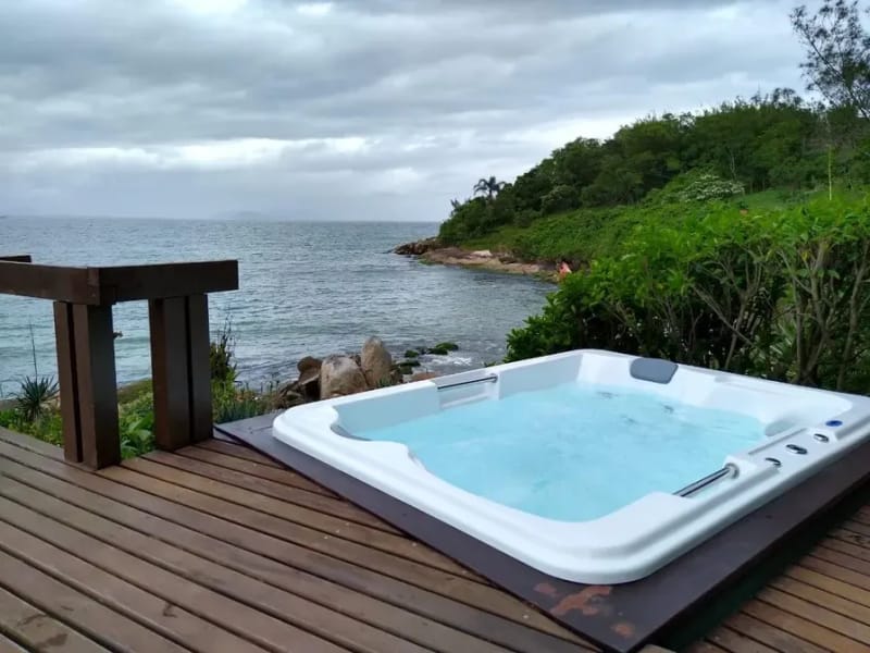Spa embutido em deck de madeira com vista para o mar na Costa Verde